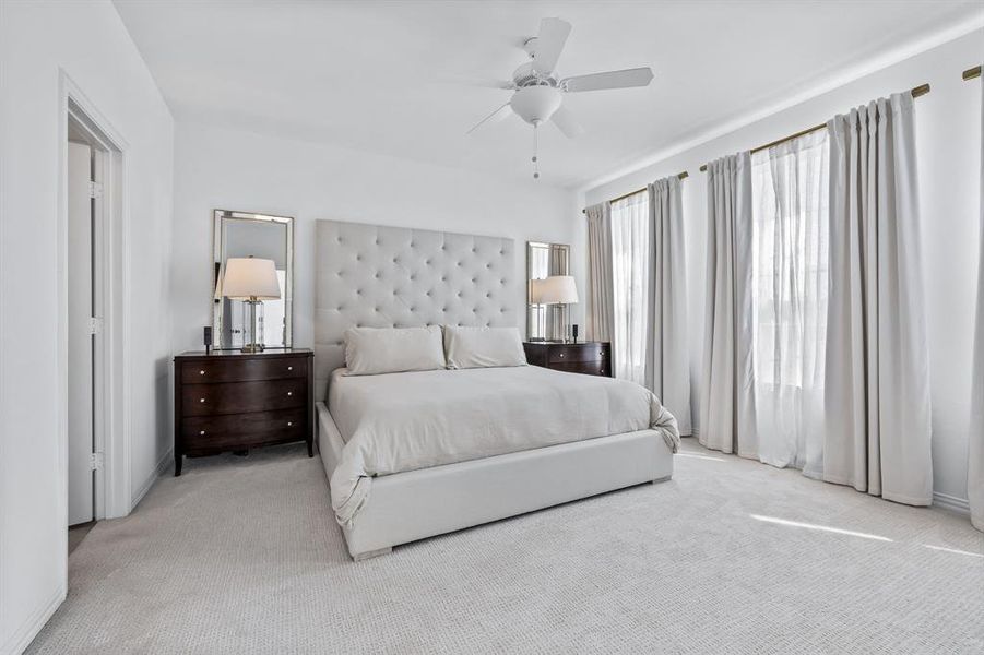 Carpeted bedroom featuring ceiling fan