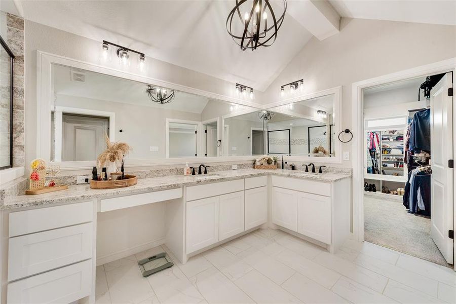 Bathroom featuring vanity, lofted ceiling with beams, and a notable chandelier