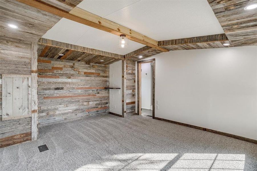 Additional living space with lofted ceiling, carpet, and wooden walls