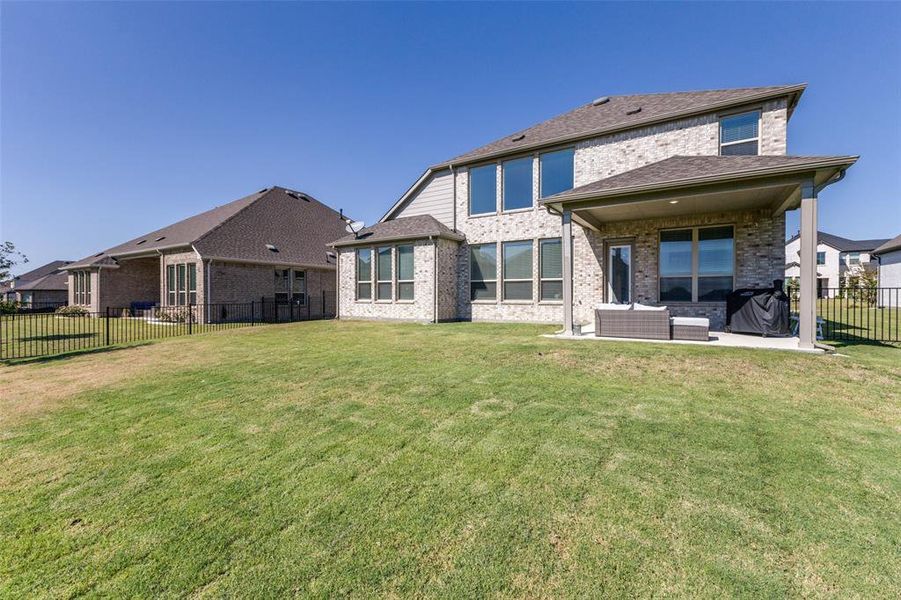 Rear view of house with an outdoor living space and a large lawn