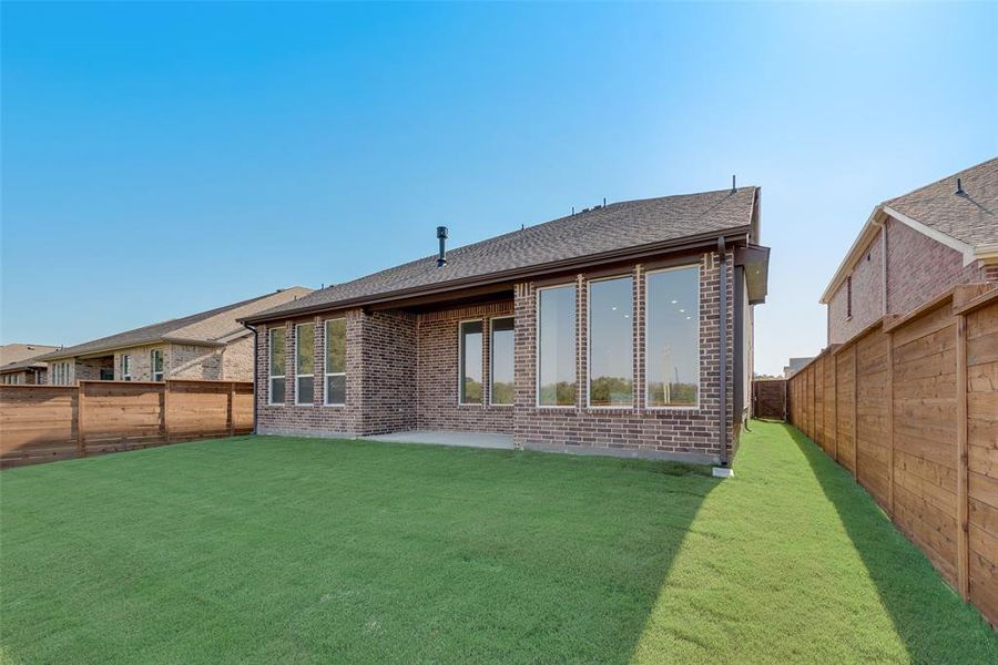 Back of property featuring a lawn and a patio