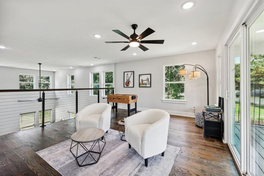 Living area with plenty of natural light, dark hardwood / wood-style flooring, and ceiling fan