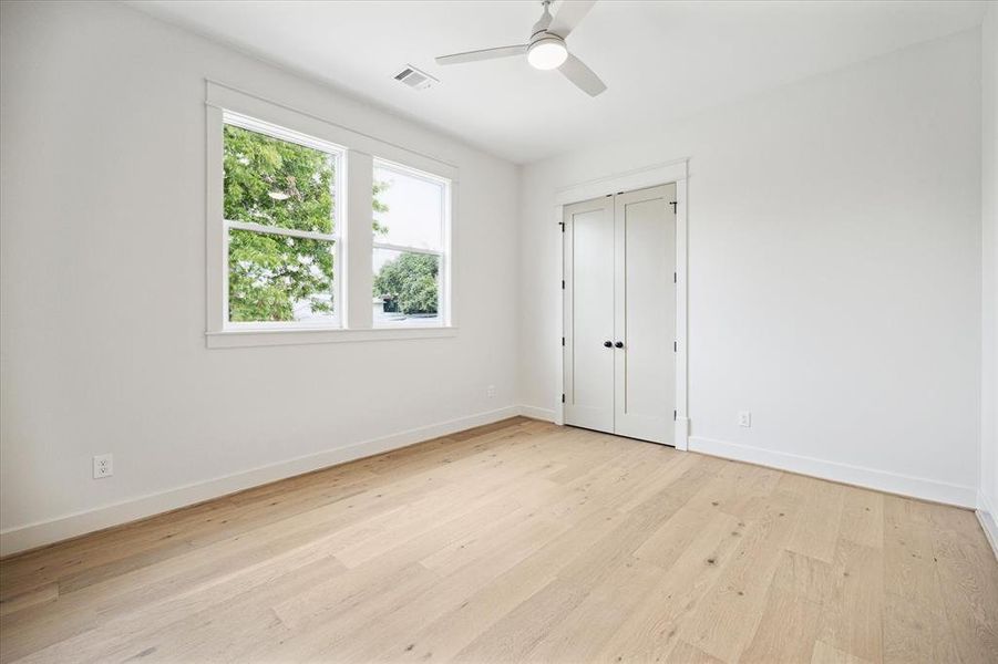 Second bedroom with gorgeous floors, two large windows, a closet and ceiling fan. This room is located in an alcove with a nearby full bath, so it would functions as lovely guest bedroom. There is also an access panel to the floored attic in this room- the amount of storage space is incredible!