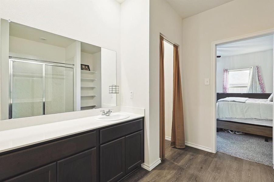 Bathroom with vanity, a shower with shower door, and hardwood / wood-style floors