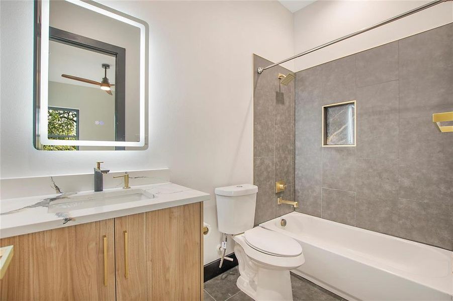 Full bathroom with tile patterned flooring, tiled shower / bath, toilet, vanity, and ceiling fan
