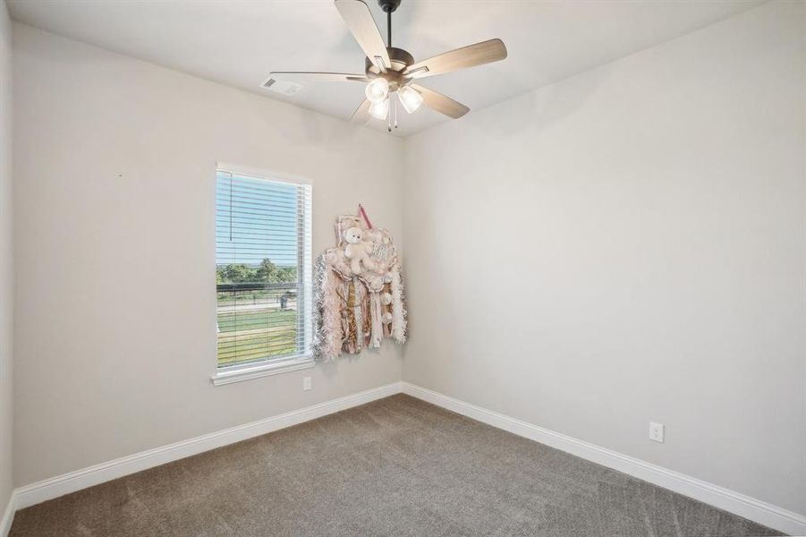 Carpeted empty room with ceiling fan