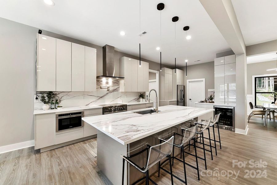 Chef's Kitchen features quartz counters, oversized island with seating/storage, 2 sinks, stainless steel appliances including 2 ovens, dishwasher & separate dishwasher drawer, Refrigerator to remain, amazing, modern cabinetry, modern, custom lighting & induction cook top!