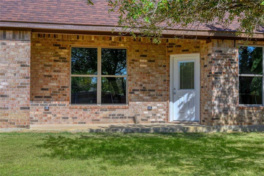 Doorway to property featuring a lawn