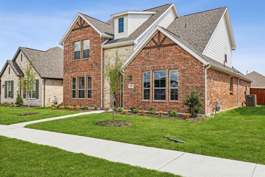 View of front of home with central air condition unit and a front yard