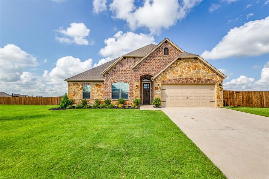 View of front of property with a garage and a front lawn