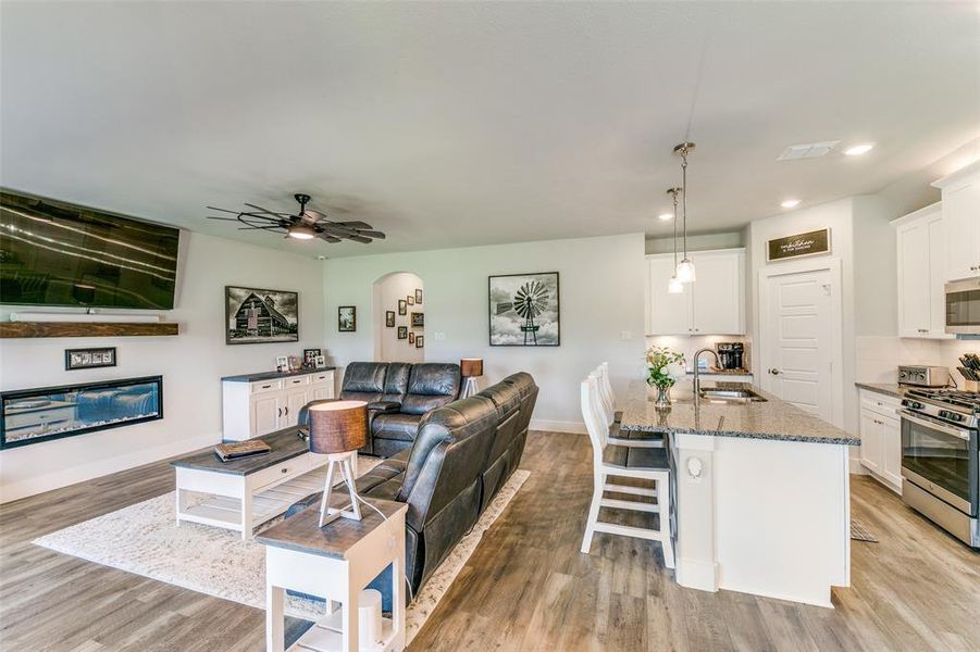 Living room with ceiling fan, light hardwood / wood-style flooring, and sink