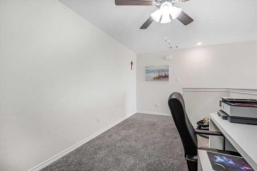 Unfurnished office featuring ceiling fan and carpet