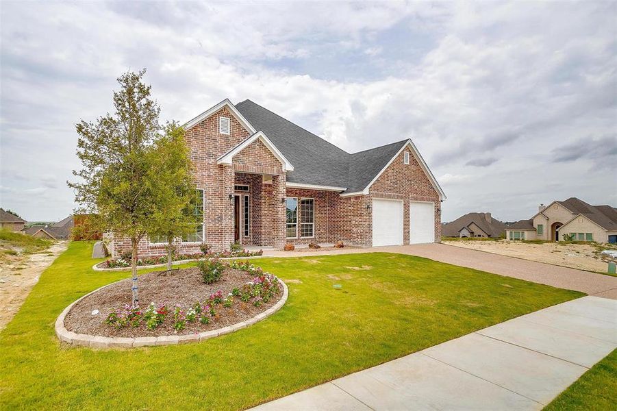 View of front facade featuring a front yard and a garage