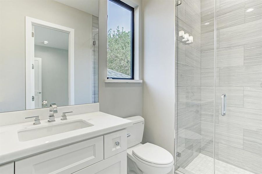 One of 4 full bathrooms elegantly appointed with designer selected counters, beautiful tiled wall to the ceiling and Baldwin hardware.