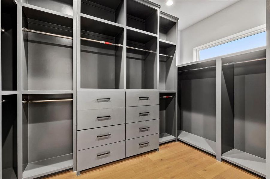 Spacious closet with light hardwood / wood-style flooring