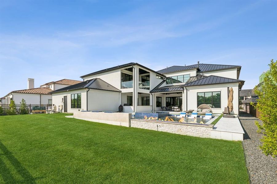 Back of house with a lawn, a balcony, a swimming pool, and a patio