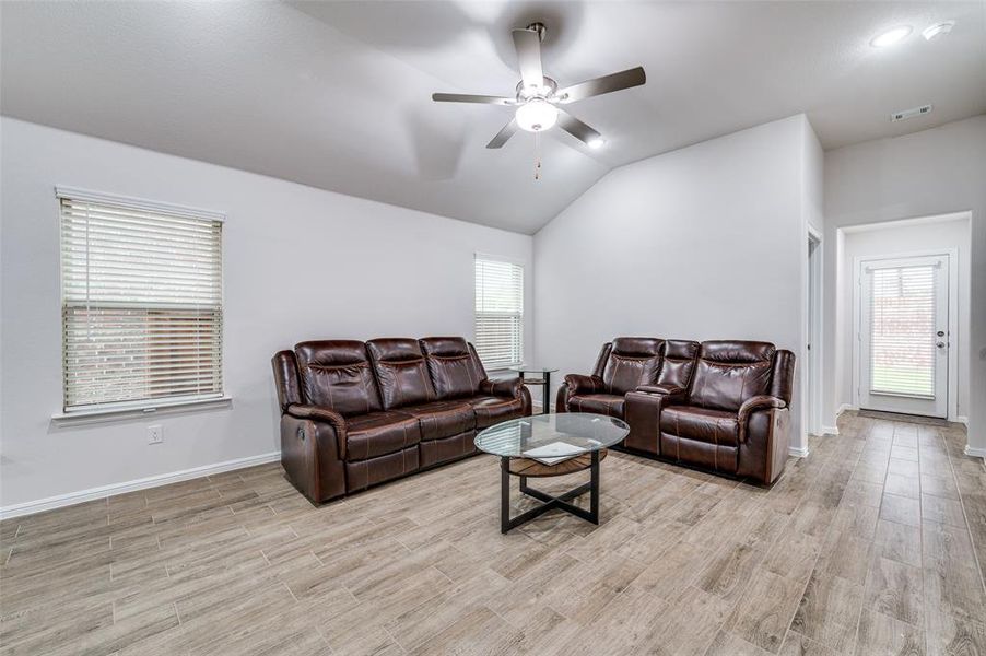 Living room with a wealth of natural light, ceiling fan, and light wood-type flooring