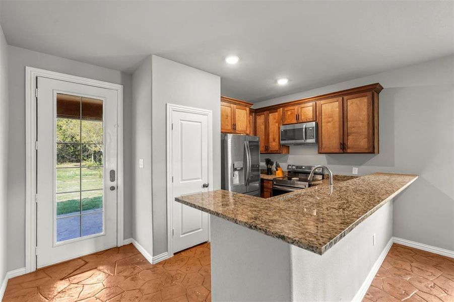 Kitchen featuring a kitchen peninsula, and stone counters