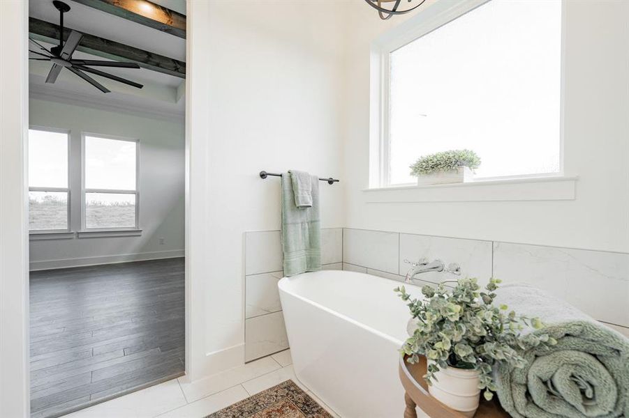 Bathroom featuring a bath, a healthy amount of sunlight