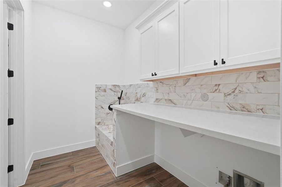 Efficiency meets luxury in the centrally located laundry room. Enjoy the convenience of a luxury pet shower and direct access to the primary closet for added functionality. Upgraded quartz countertop and cabinets here too!