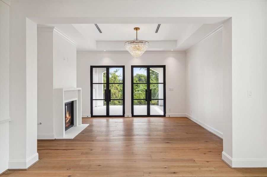 This luxurious primary retreat features a cozy breakfast bar and a custom fluted cast stone fireplace, creating an intimate and inviting atmosphere. Two sets of Durango doors open to a private balcony, allowing for a seamless indoor-outdoor connection and stunning views.