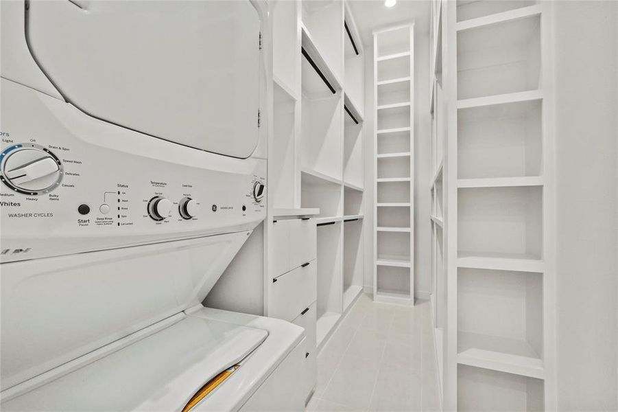 Spacious closet featuring stacked washer / dryer and light tile patterned floors