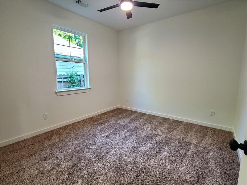 Carpeted empty room with ceiling fan