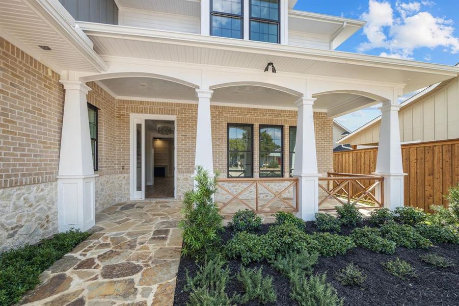 Property entrance featuring covered porch and stone path