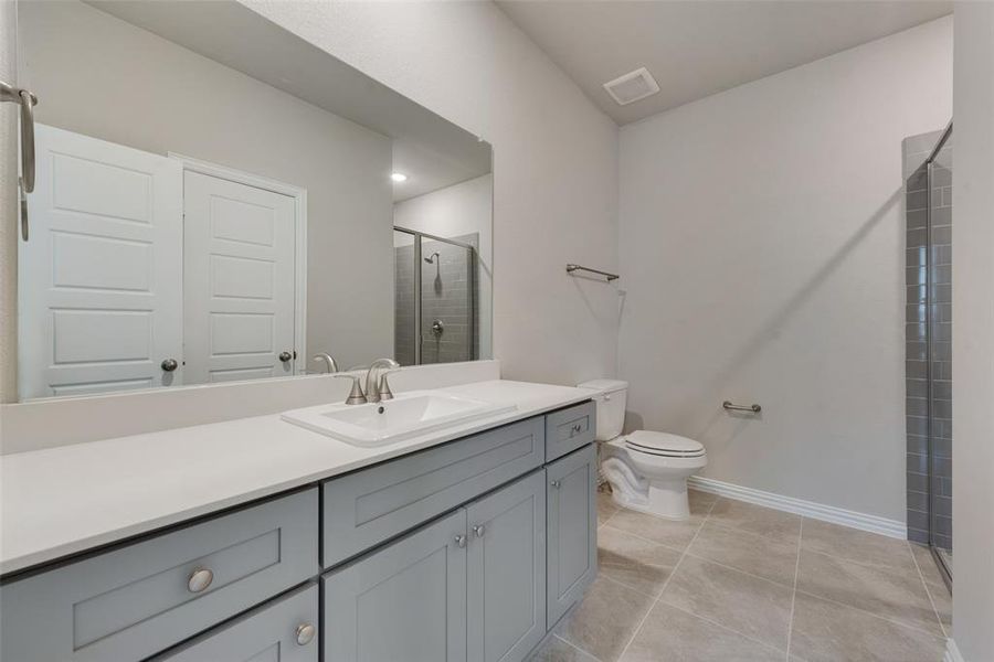 Bathroom featuring vanity, tile patterned floors, and toilet