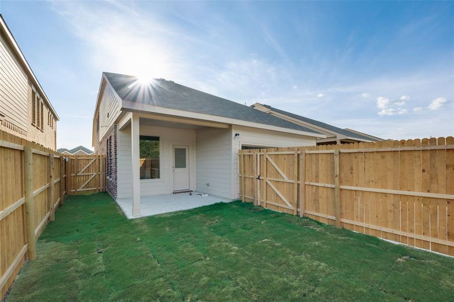 Rear view of house with a patio area and a yard