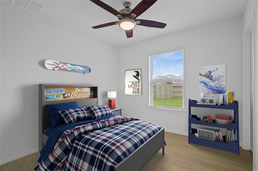 Secondary bedroom features vinyl plank flooring, ceiling fan, custom paint and a large window.