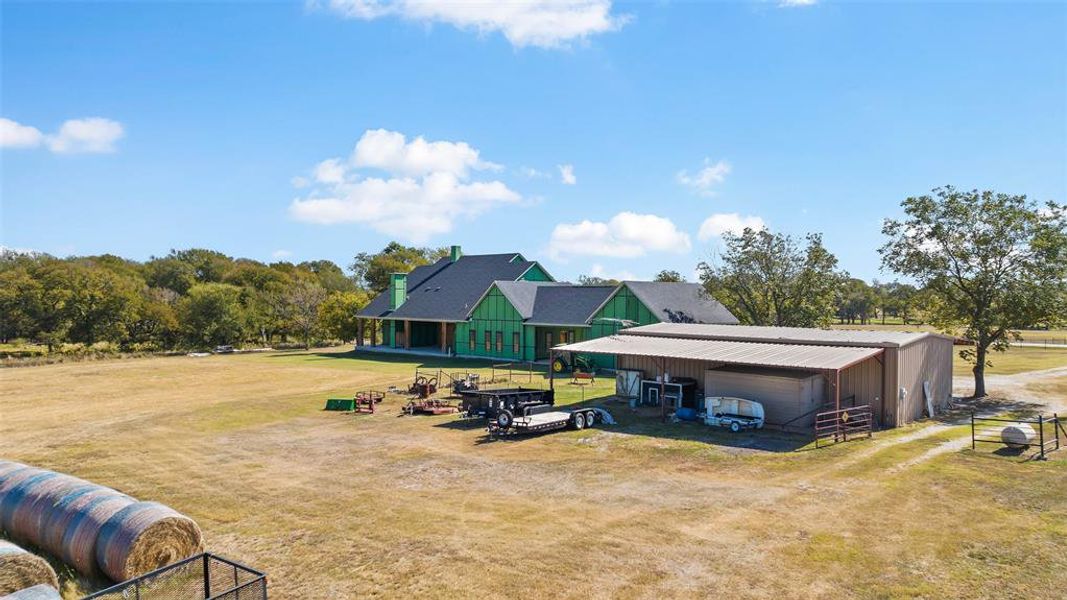 Rear view of house featuring a yard, a garage, and an outdoor structure