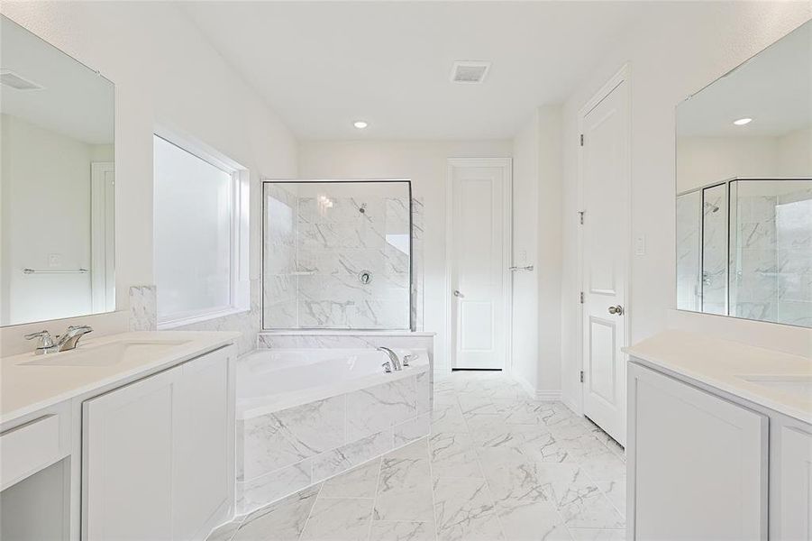 Bathroom featuring vanity and independent shower and bath