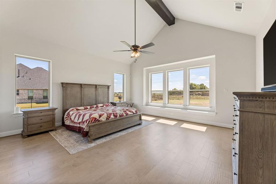 Bedroom with beam ceiling, ceiling fan, light hardwood / wood-style flooring, and high vaulted ceiling