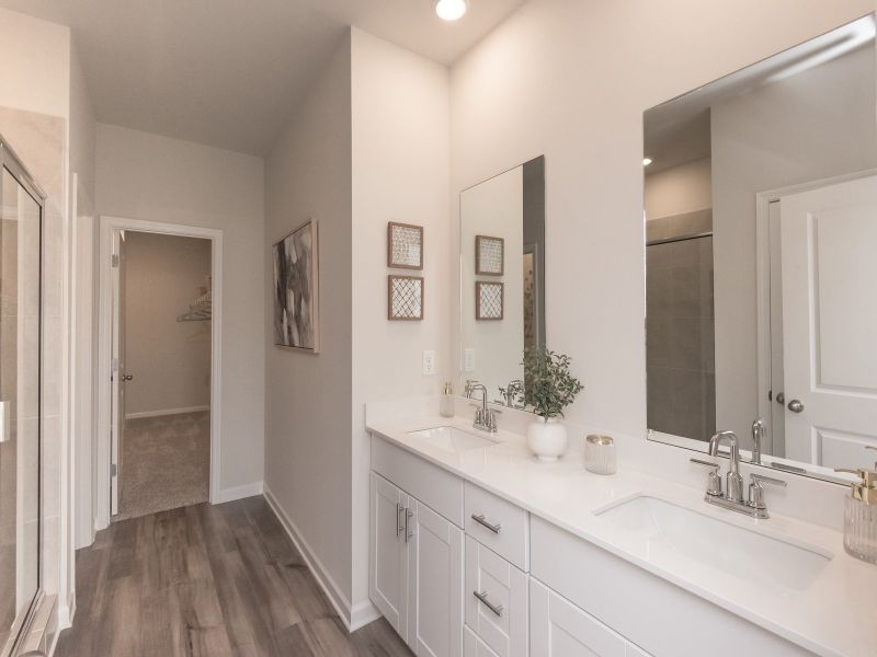 The ensuite bathroom features dual-vanity sinks and a walk-in closet.