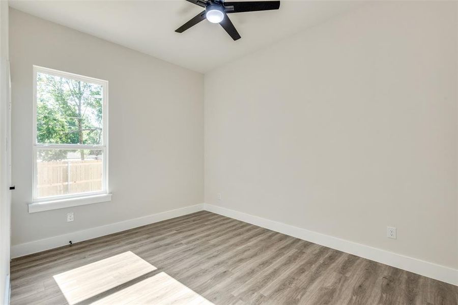 Unfurnished room with ceiling fan and light hardwood / wood-style flooring