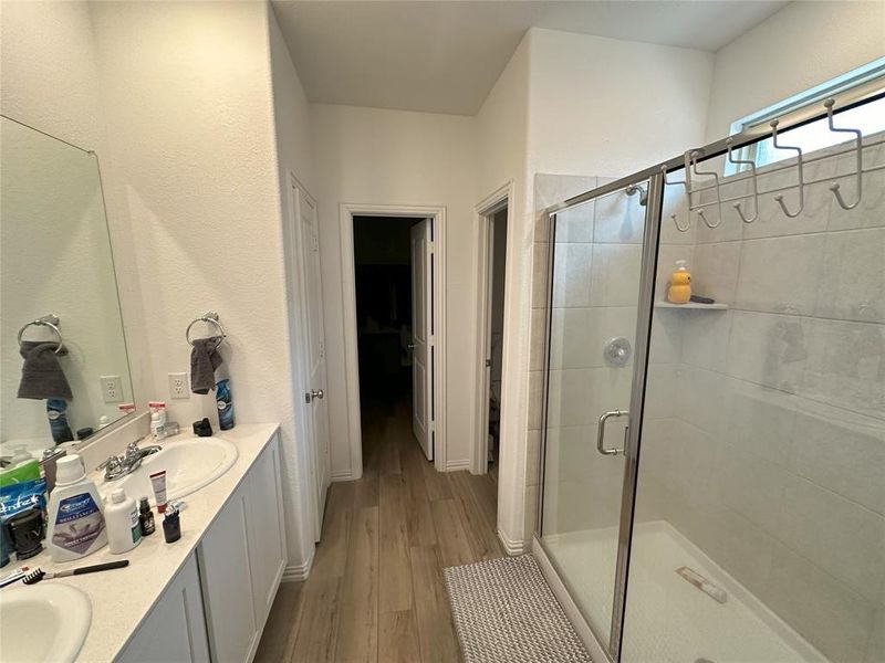 Bathroom featuring vanity, hardwood / wood-style floors, and an enclosed shower