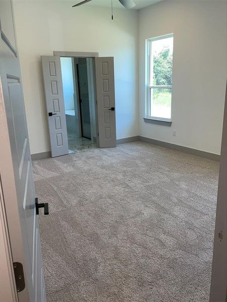 Unfurnished bedroom featuring carpet and ceiling fan