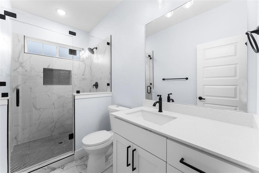 Bathroom with a shower with shower door, toilet, and vanity