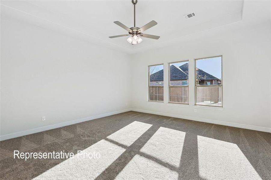 Unfurnished room featuring ceiling fan and dark carpet