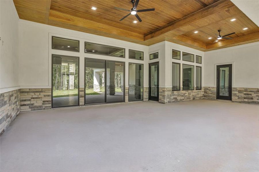 Walls of glass windows & doors open to the 941 sf Covered Patio with stucco and stone finishings.