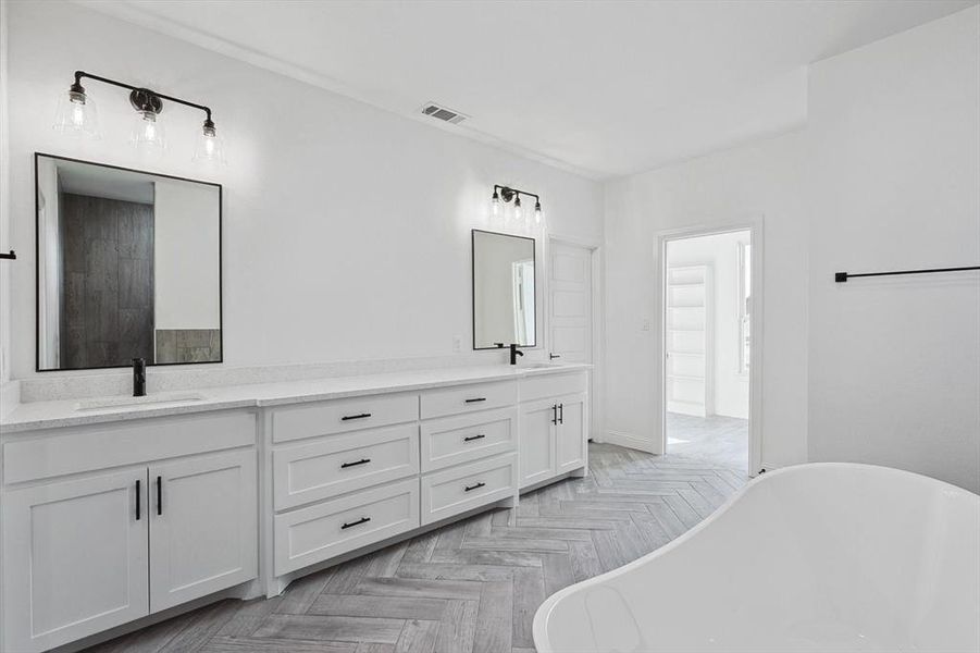 Bathroom with parquet flooring, a tub, and vanity