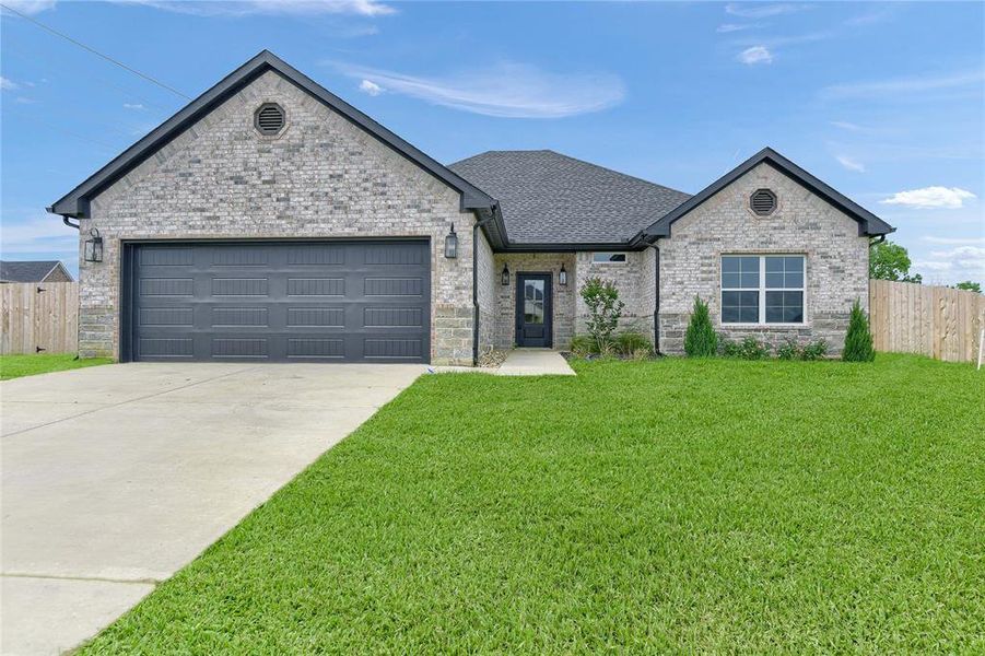 View of front of property with a garage and a front yard