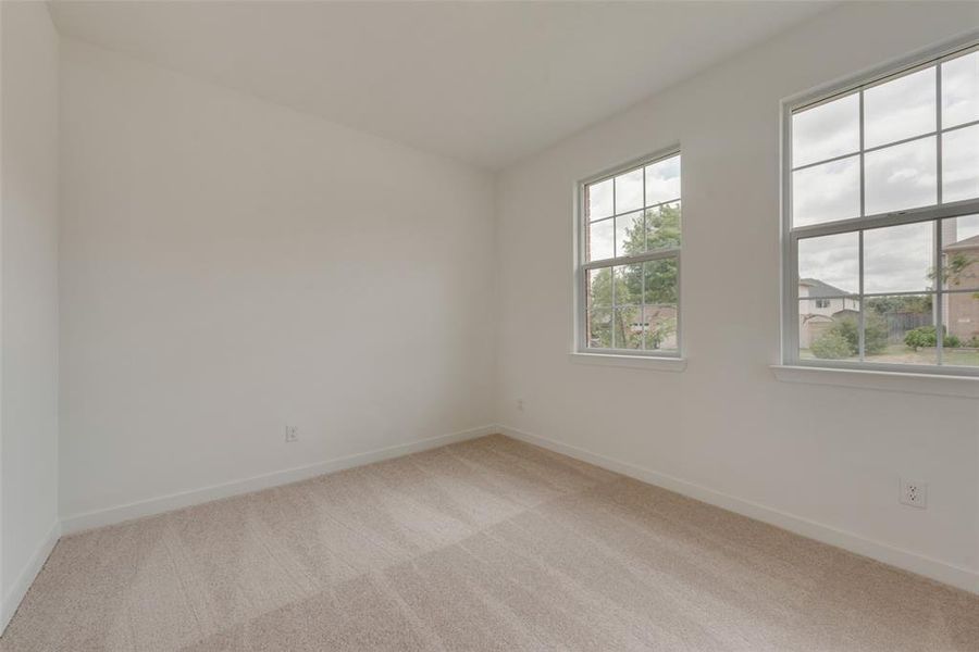 Unfurnished room featuring light carpet and a healthy amount of sunlight