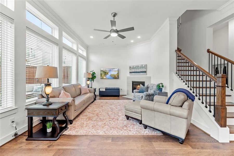 Main Living Room with Wall of Windows Crown Molding, Fireplace with Tile Surround. Perfect for Entertaining!