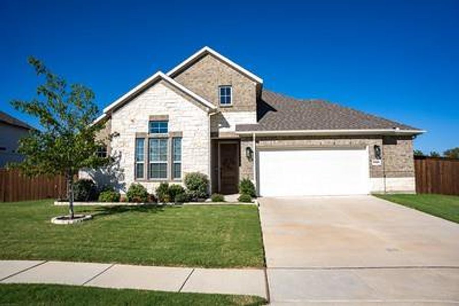 View of front of property featuring a garage and a front yard