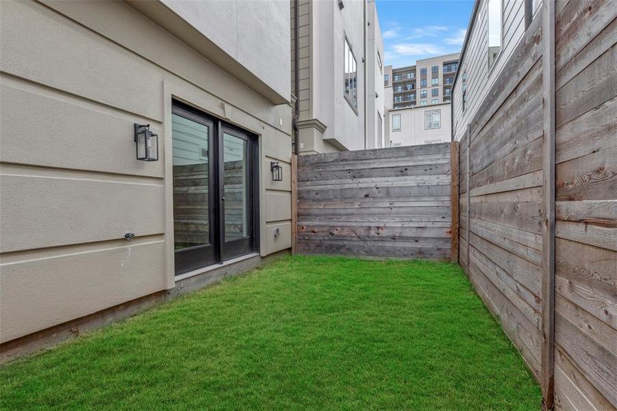 The property includes a fenced backyard, enclosed by a high wooden fence for added privacy.