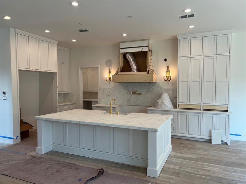 Kitchen features Thermador Appliances, Pegasus dolomite countertops, brass fixtures and hardware, sconce and pendant lighting, plastered venthood.