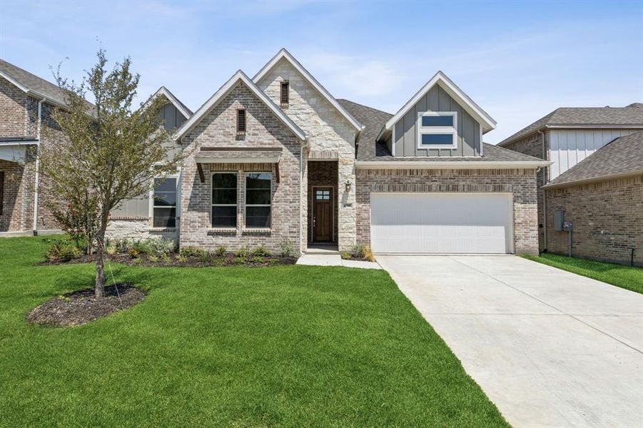 View of front facade featuring a garage and a front yard