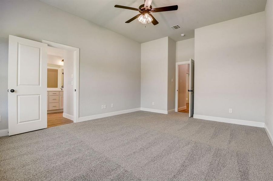 Carpeted spare room featuring ceiling fan